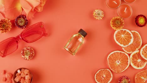orange-themed perfume and accessories flat lay