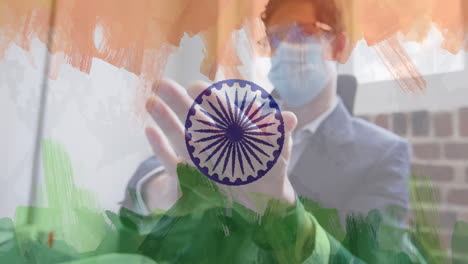 composition of businessman wearing face mask disinfecting his hands in office over indian flag