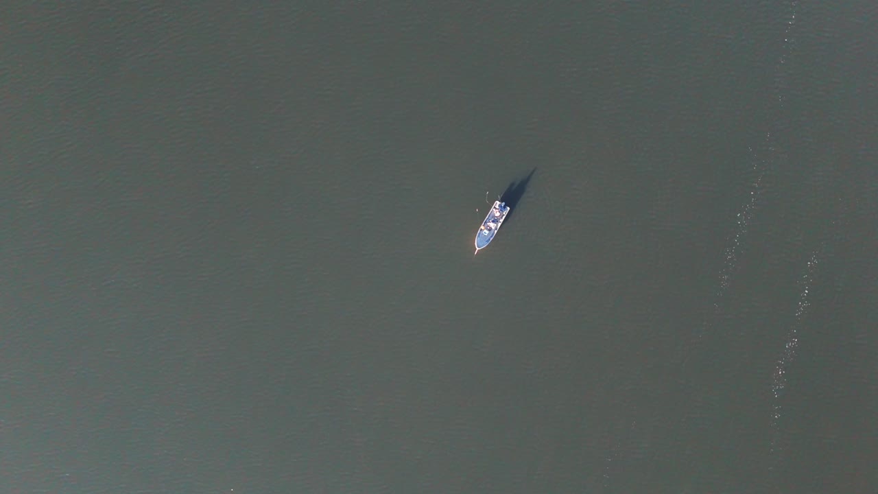 Ripresa aerea in discesa di pescatori che pescano da una piccola barca