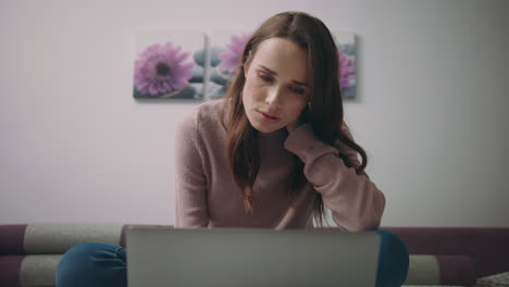 Tired-woman-watching-online-news-at-laptop-computer.-Student-online-education