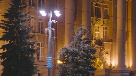 snowy city street at night with modern lampposts