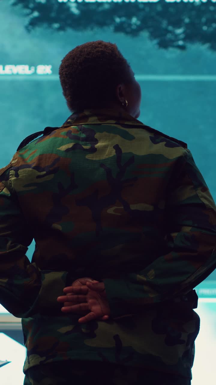 Soldier in Camouflage Uniform Observing Data on Large Screen