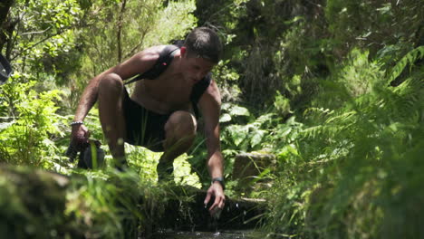 hombre siente agua levada fría en acueducto en maderia portugal, cámara lenta
