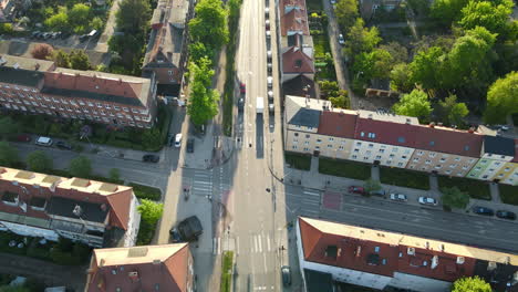 aerial drone flight showing road with driving cars in old town of gdansk during sunny day