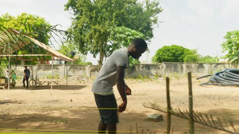 Mann-Aus-Ghana-Bereitet-Kente-Stofftextilien-Zwischen-Bananenstauden-In-Einem-Dorf-In-Ghana-Vor