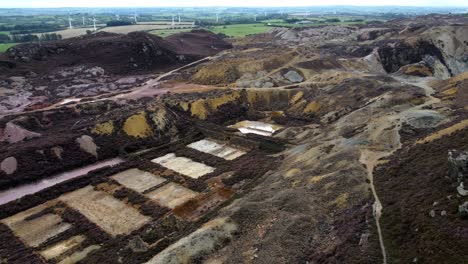 parys mountain abandoned historic copper mine red stone mining industry landscape aerial view rising pan right