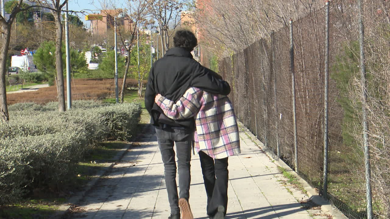 한 커플 이 도시 공원 에서 산책 하고 있다