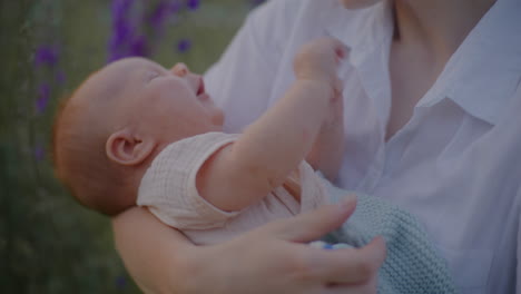 mother holding newborn with blossoming flowers