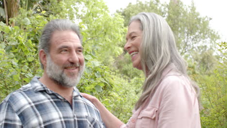 happy mature couple embracing outdoors, enjoying nature and smiling together