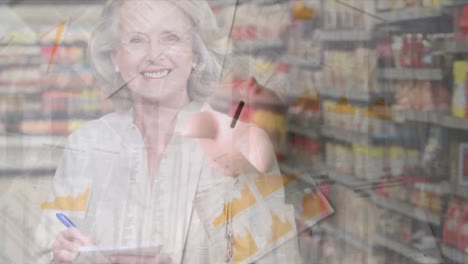 la alcancía contra la mujer mayor tomando notas mientras hace las compras de comestibles