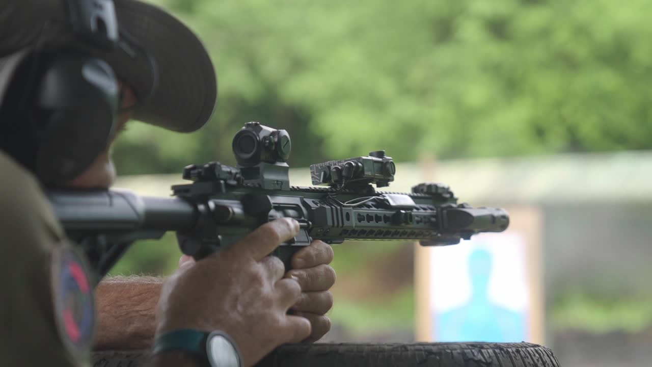 Male soldier during MILITARY TRAINING shooting with TACTICAL EQUIPMENT RIFLE Weapon. Close up slow motion.