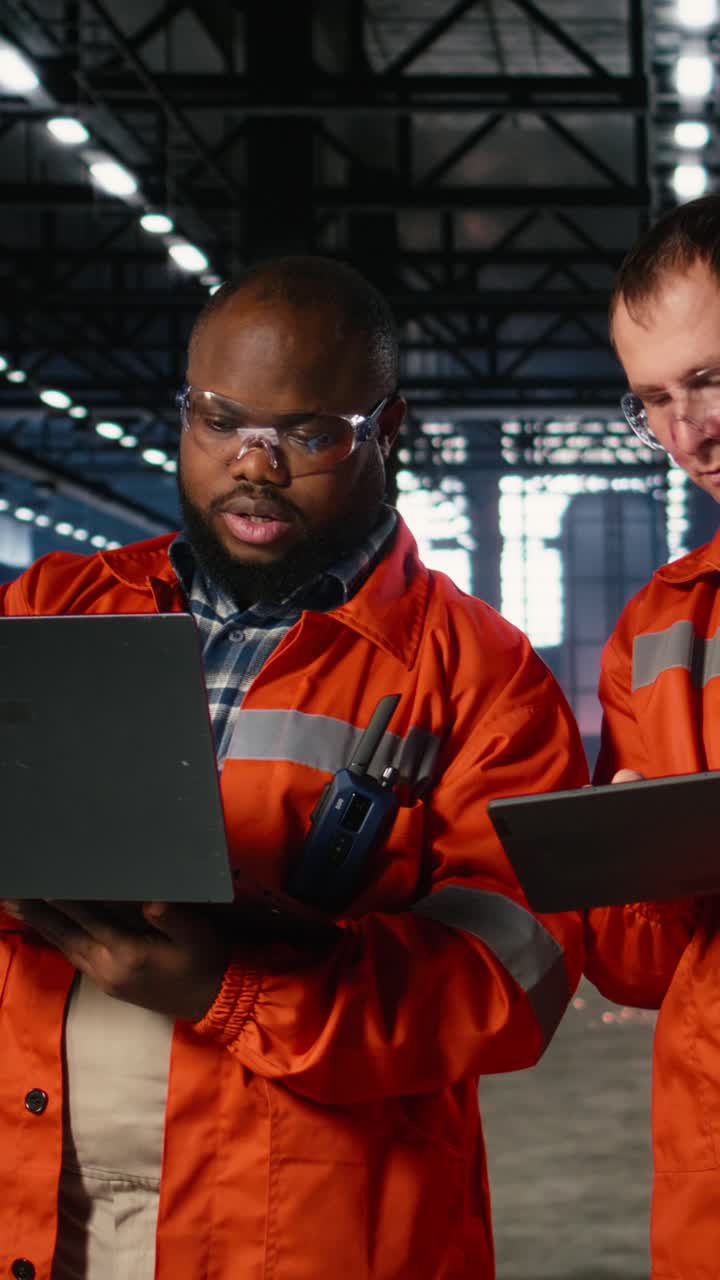 Vertical Video Industrial staff oversees plant operation with gadgets surrounded by tools
