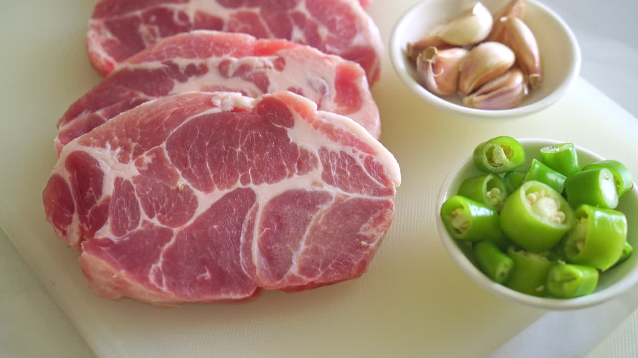 절인 재료를 곁들인 신선한 돼지목 목살 또는 칼라 돼지고기