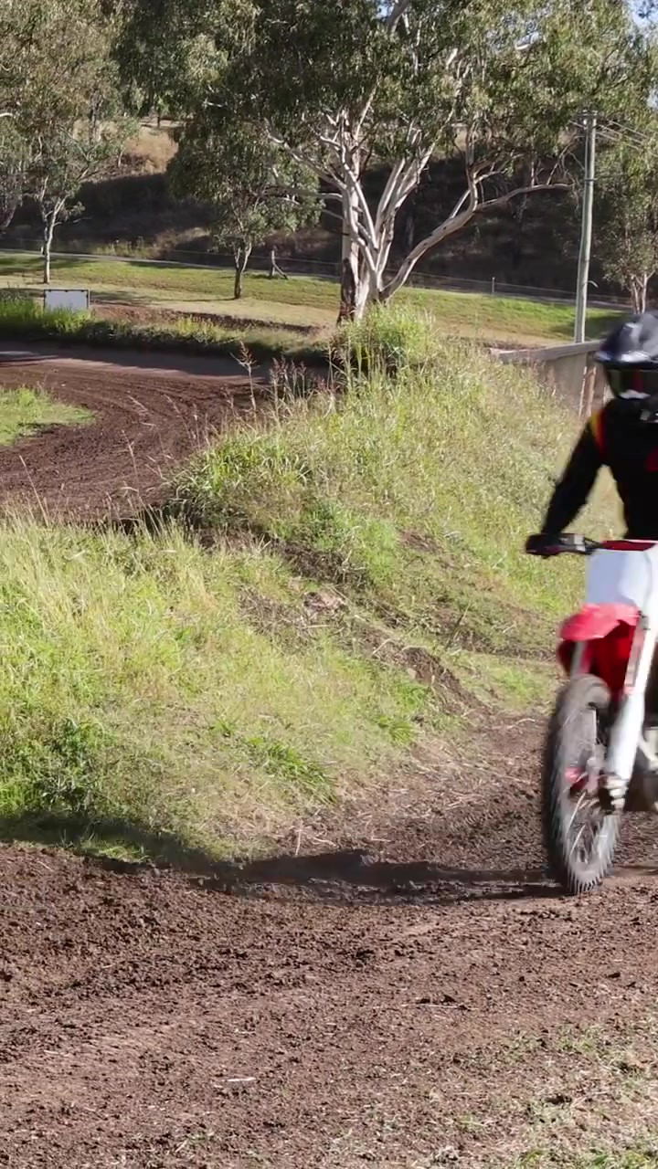Motociclisti percorrono con abilità una pista sterrata.
