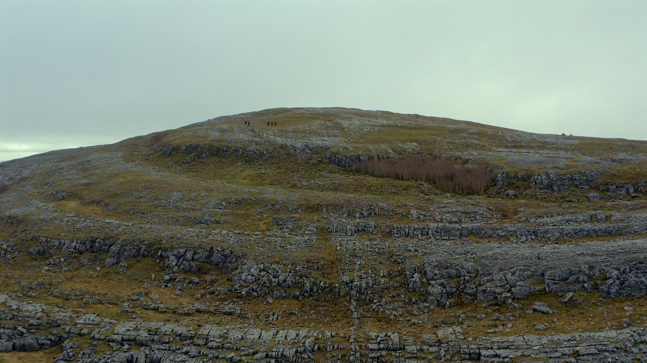 Aerial dolly approaching Mullaghmore Peak with mountaineers taking a break. Burren National Park