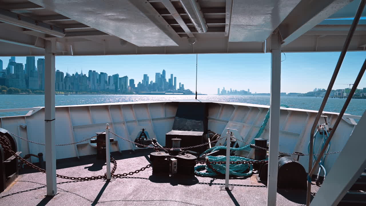 Blick auf die Skyline der Stadt von einem Boot im Wasser an einem sonnigen Tag. Ein Boot befindet sich im Wasser mit Blick auf die Skyline einer Stadt in der Ferne unter einem klaren Himmel