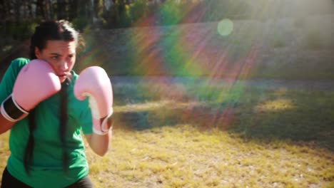 Determined-women-practicing-boxing-during-obstacle-course