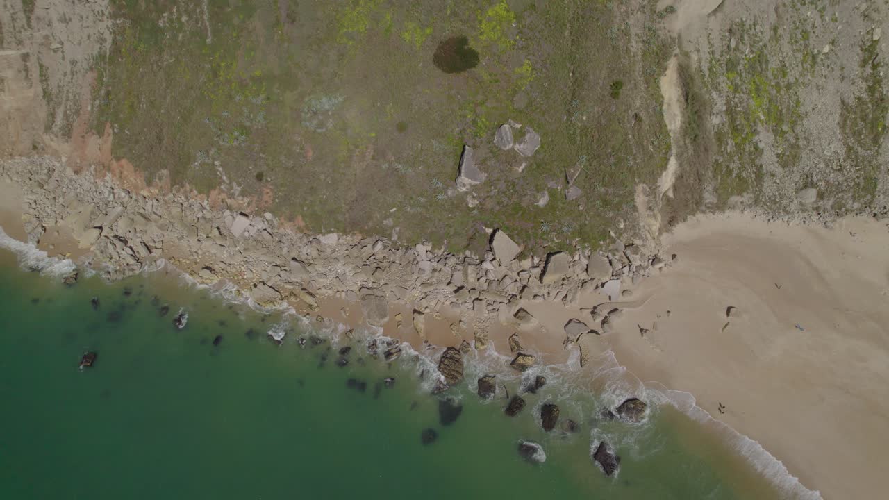 fotografía aérea de las olas tranquilas del océano que se estrellan contra la costa rocosa de nazare, portugal