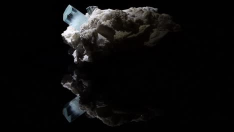 a single very clear crystal of aquamarine emerges from a feldspar matrix