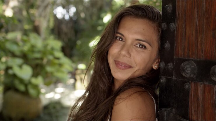 mujer relajada apoyándose en una puerta de madera