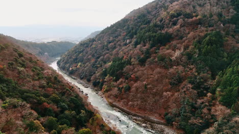 narrow shallow river of katsura in the beautiful mountains. aerial view on the nature of kyoto, japan on sunny day. aerial view.