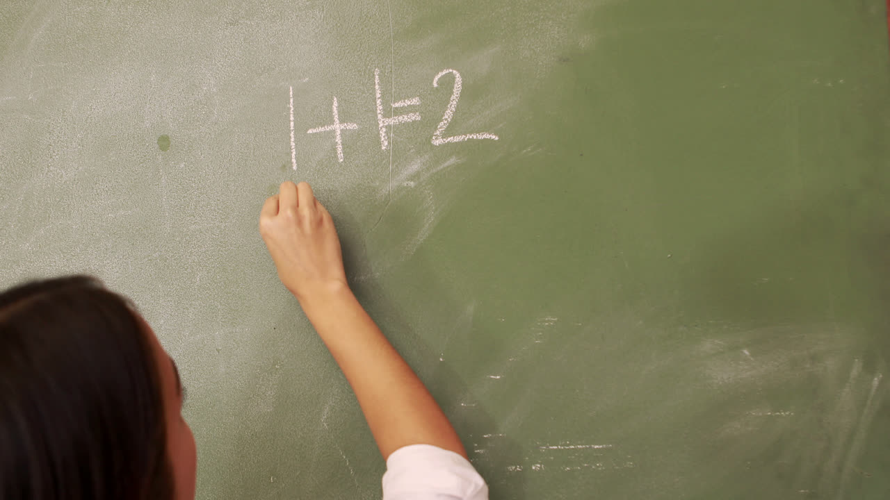 Teacher writing on blackboard
