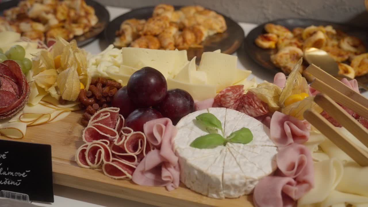 Buffet table filled with a delicious selection of food including ham, cheese, and various refreshments arranged elegantly for a festive reception