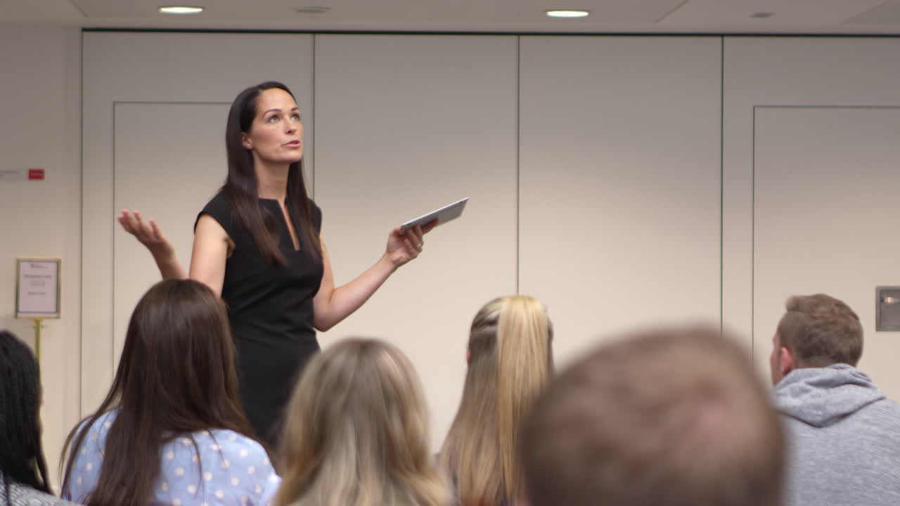 maestra dirigiéndose a estudiantes universitarios en clase, filmada en r3d