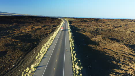 aerial tracking athlete cycling road bike on king kamehameha highway, hawaii drone 4k