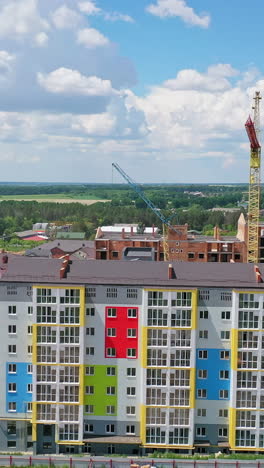 modern urban district building in the construction site. front view of a modern newly built high rise apartment. drone view. motion camera back. vertical video