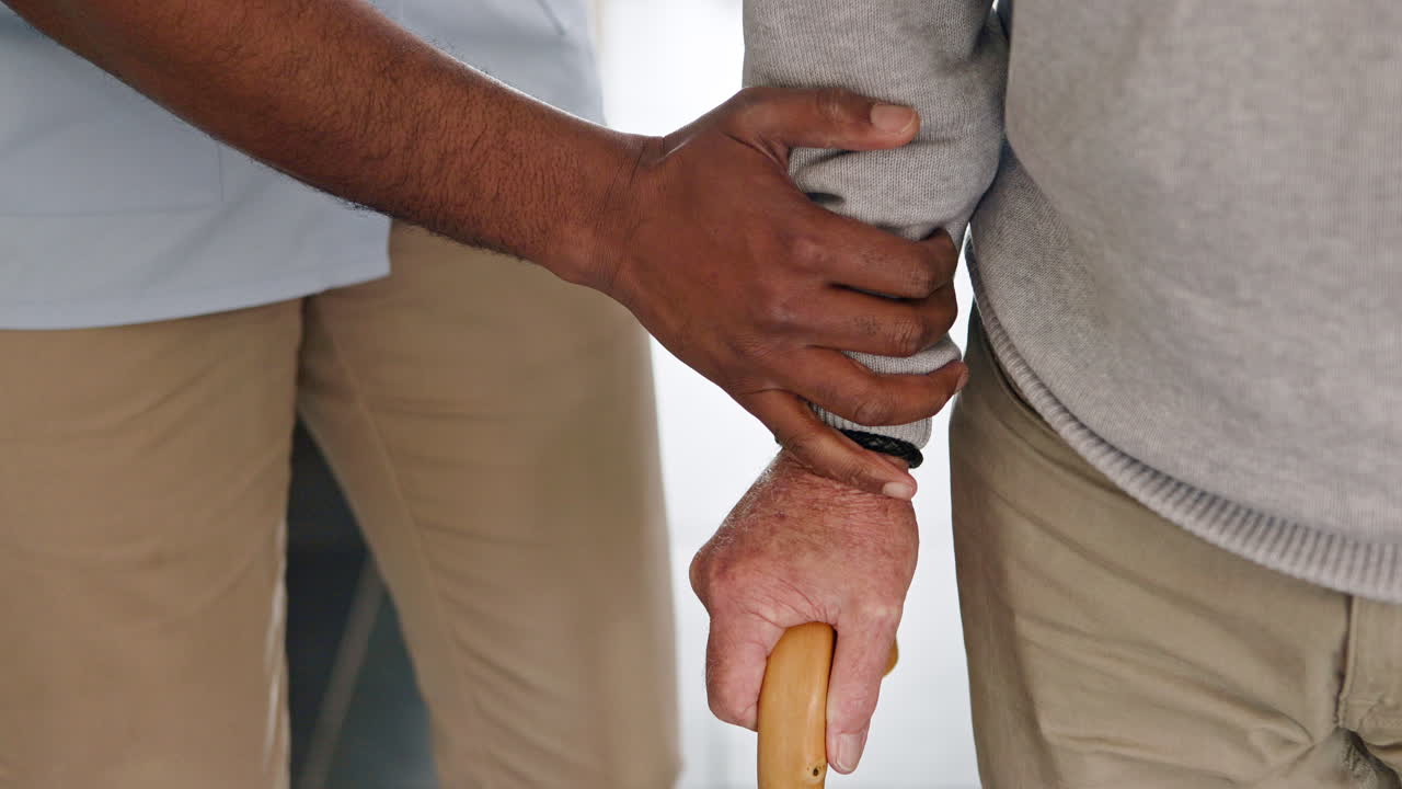 Caregiver assisting senior man with walking stick