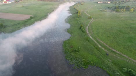 lago del bosque en la niebla de la mañana, en los rayos del sol del amanecer