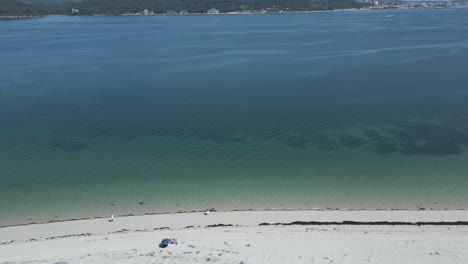 vista aérea de un hombre caminando solo en una playa vacía durante los tiempos de la epidemia - covid
