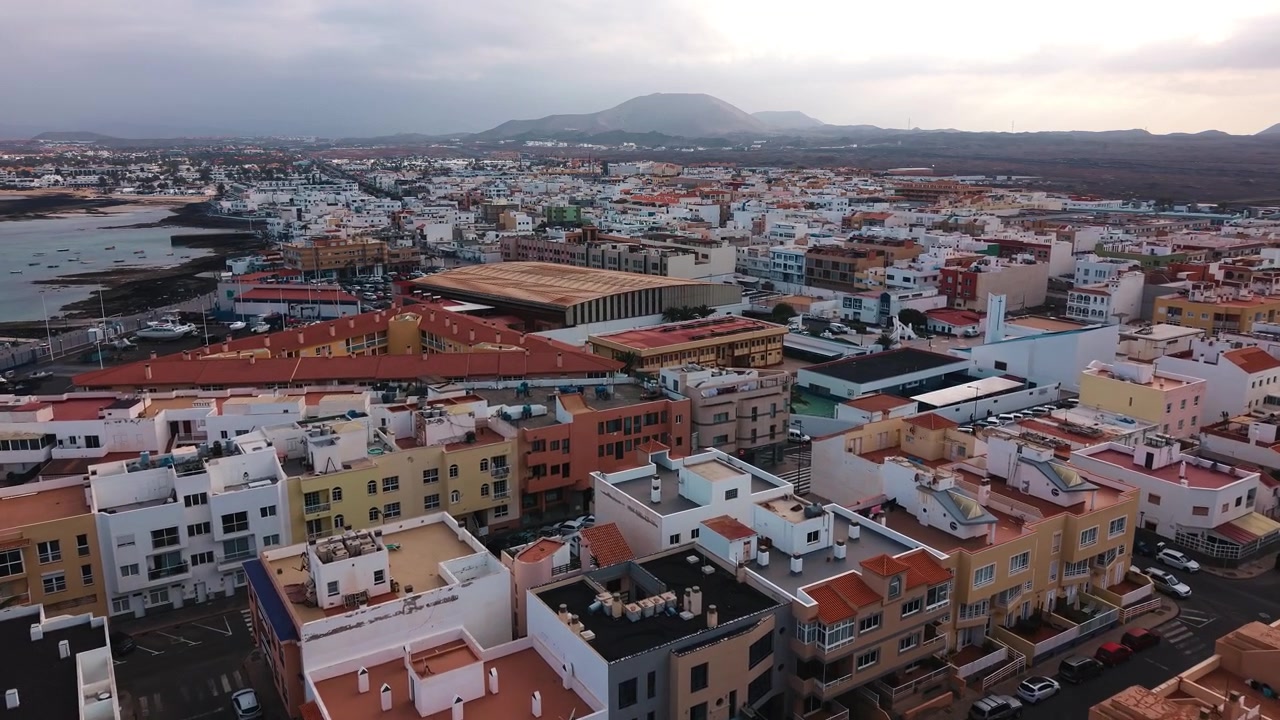 Vista aerea di città costiera con montagne sullo sfondo