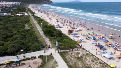 vista aérea de la playa turística tropical con hoteles y casas de verano frente al mar con mucha gente en la arena