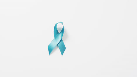 Video-of-blue-ovarian-cancer-awareness-ribbon-on-white-background-with-copy-space