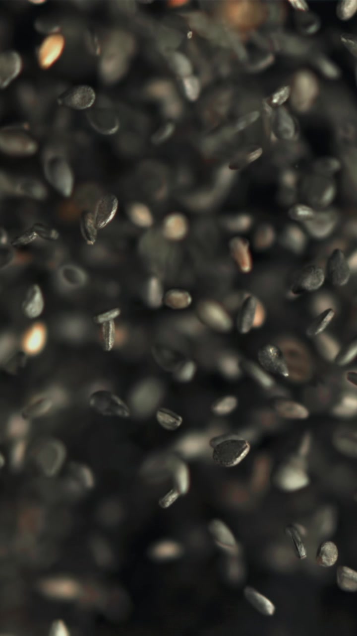 Semillas de sésamo negras cayendo en súper cámara lenta