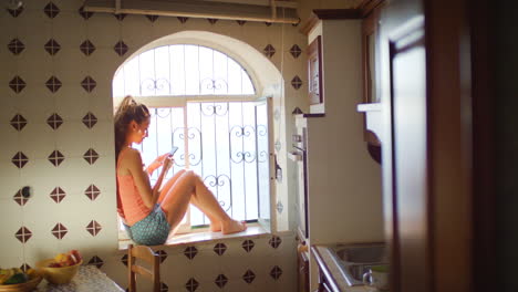 una hermosa mujer joven sentada en su cocina