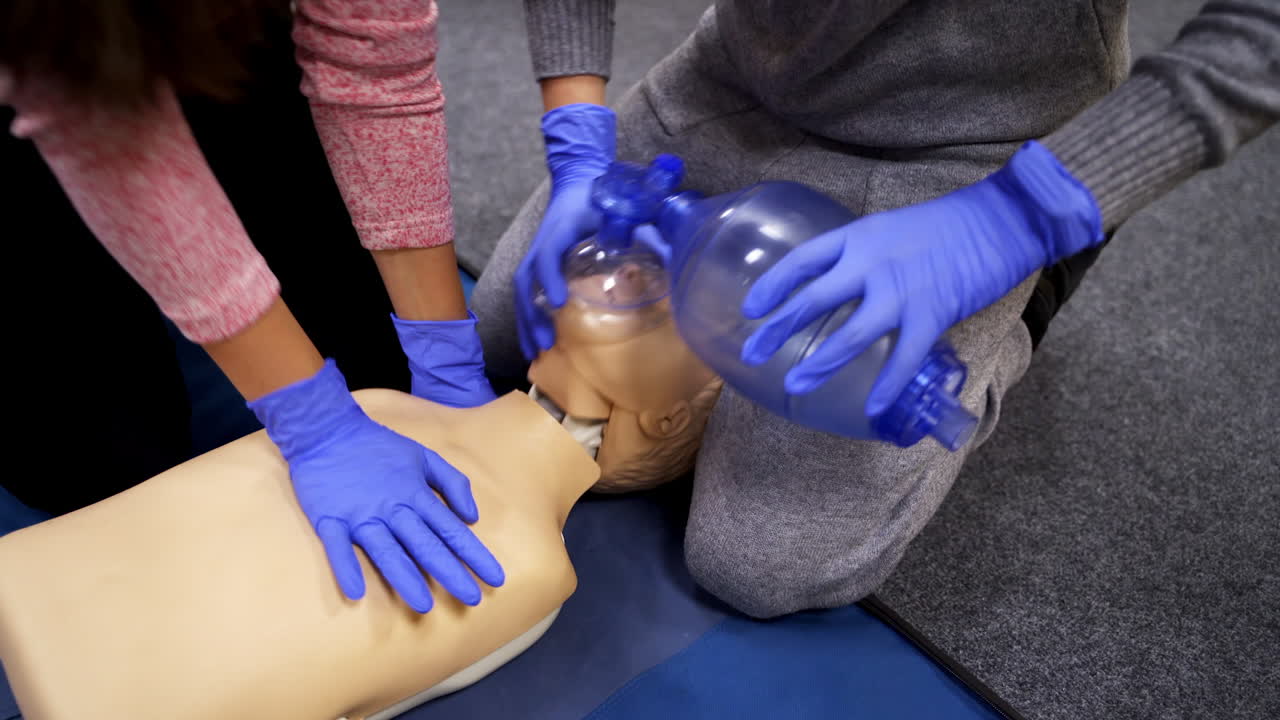Saving patient's life on a dummy. Students practice medical learning on a mannequin. Medical training course for resuscitation.