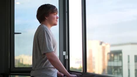jovem olhando pela janela para a vista da cidade