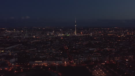 Nachtflug-über-Großstadt.-Luftaufnahme-Der-Städtischen-Nachbarschaft-Und-Der-Stadt-Dominierend,-Hoher-Dünner-Fernsehturm-Fernsehturm.-Berlin,-Deutschland.