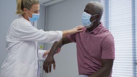 Diverse-Orthopädische-Ärztin-Untersucht-Männlichen-Patienten-Mit-Gesichtsmasken