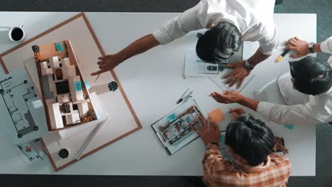 Group-of-designer-look-at-model-while-discussing-about-building.-Alimentation.