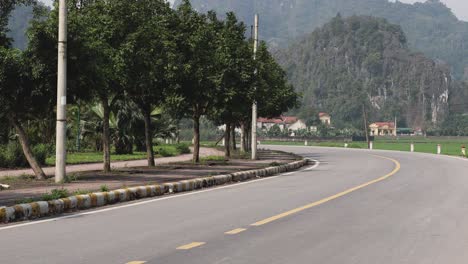 empty curved road with trees and mountains