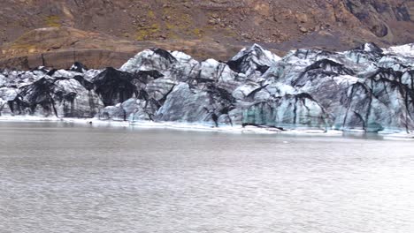 Rocky-ice-wall-aerial-panning-view-of-melting-glacier-in-Iceland