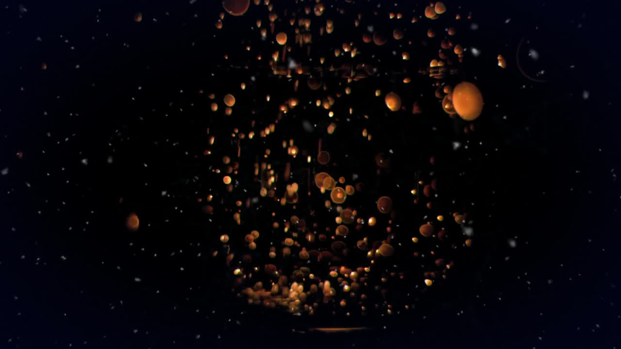 Animation of light particles and orange spheres on black background
