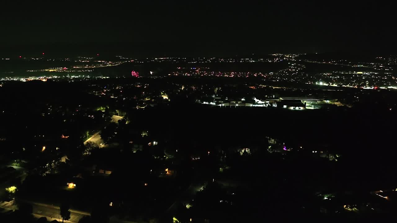 백그라운드에서 불꽃놀이가 터지면서 밤 시간 공중이 산타클라리타 상공을 날고 있다