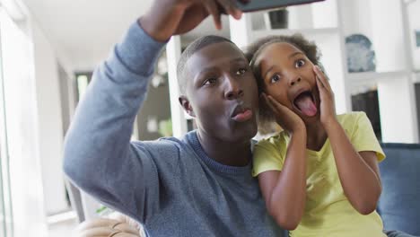 Video-of-african-american-father-and-daughter-using-smartphone