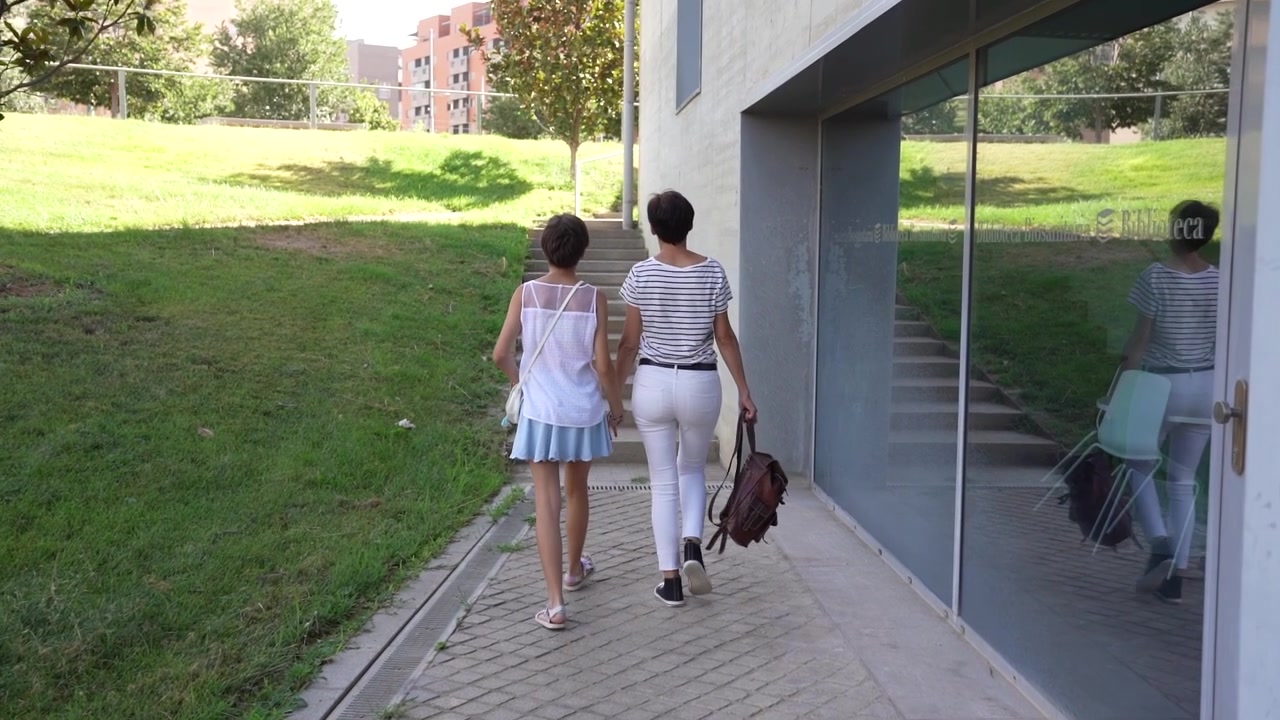 Dos amigos caminando alegremente en un entorno escénico al aire libre, disfrutando juntos de la naturaleza y el sol