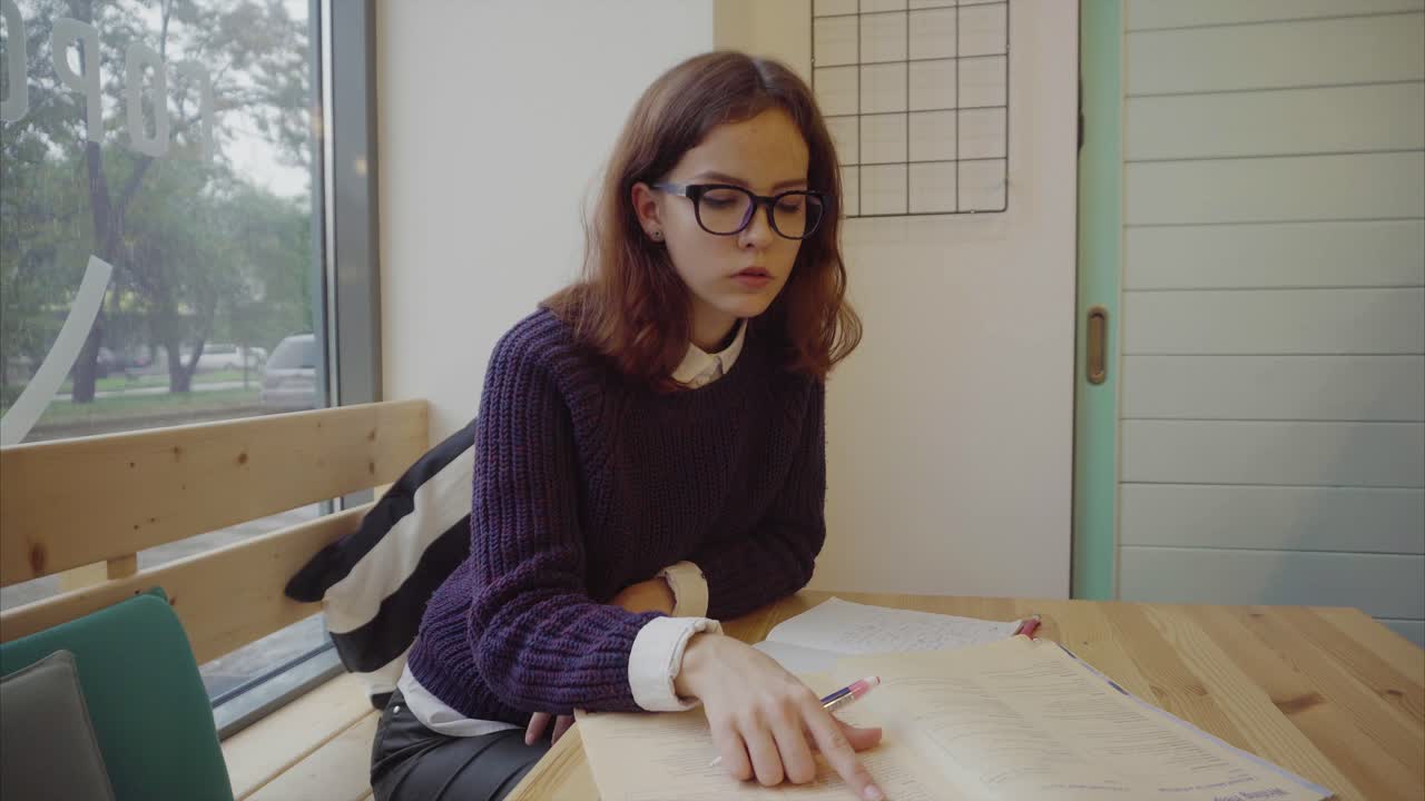 una mujer joven estudiando en un café.